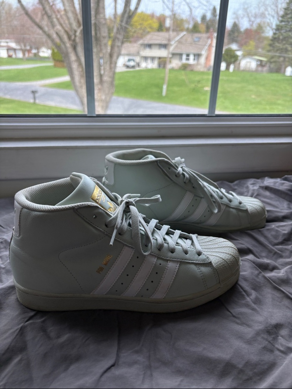 Adidas Originals Pro Model sneakers in a mint green, white, and gold colorway.